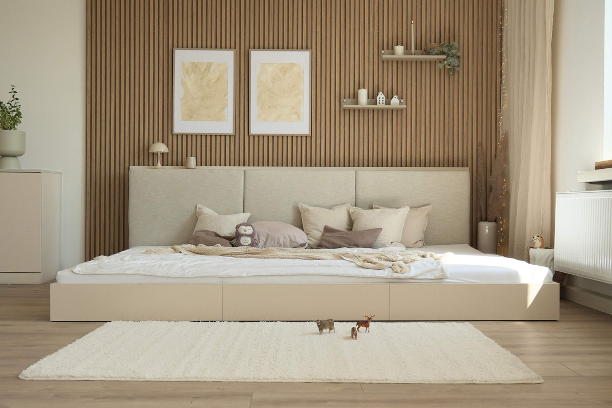 Vorderansicht des gepolsterten Bodenbetts Camilla in hellbeige in modernem, ruhigen Schlafzimmer mit beigefarbener Dekoration