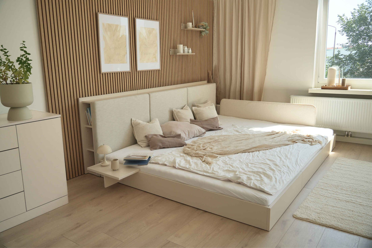 Bodenbett Camilla in hellbeige mit Rausfallschutz und Rausfallschutzpolster in hellbeige und passender Nachtablage in modernem Schlafzimmer